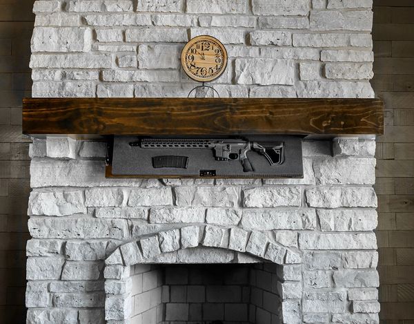 Hidden gun compartment behind a fireplace mantel with a clock above.