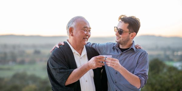 Two men enjoying a drink outdoors with smiles