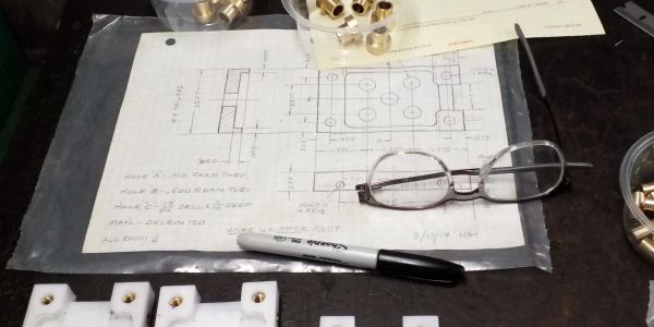 Technical drawing with glasses and a marker on a workbench.