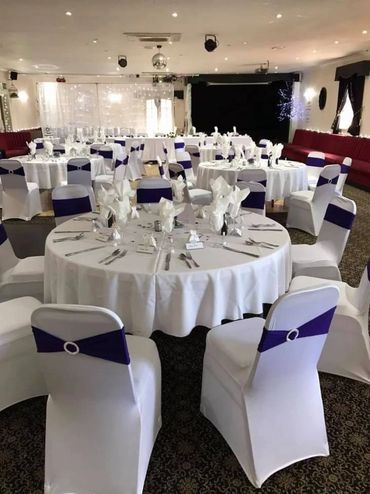 A picture of the Irish Club set up for a wedding with the tables laid beautifully.