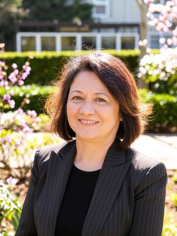 Smiling woman in a pinstripe suit outdoors.