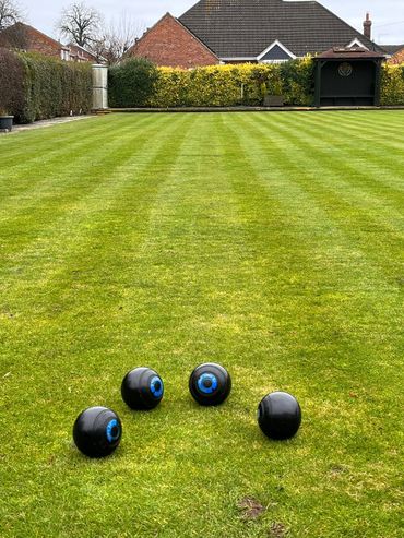 Bowling woods on a lawn at Whiitlesey Town Bowls Club