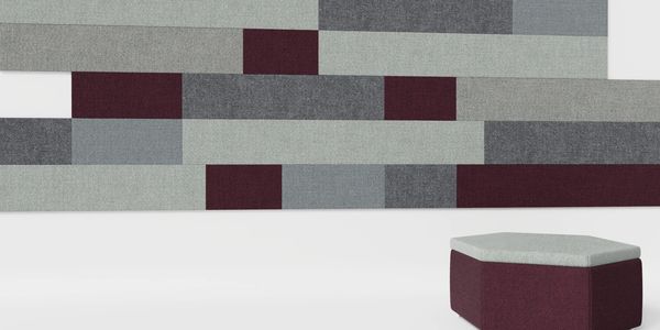 Hexagonal ottoman with gray and burgundy upholstery in front of a geometric wall panel.
acoustic tiles
custom design upholstery
sound absorption solutions