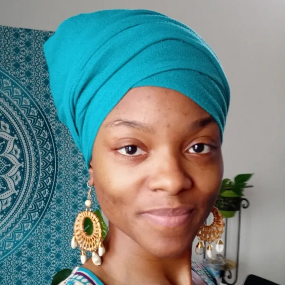 A beautiful brown skin woman of African American descent wearing a turquoise headwrap and decorative