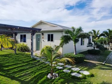 Our home surrounded by manicured landscaping and beautiful palm trees.