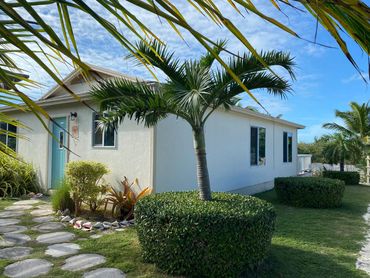 Our home surrounded by manicured landscaping and beautiful palm trees.