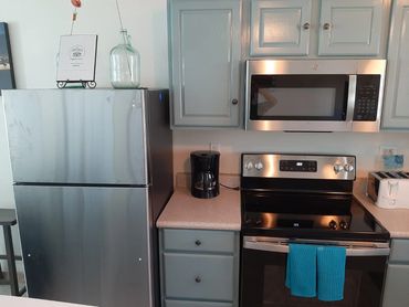 Full size kitchen appliances, fridge, stove, microwave and dishwasher.
