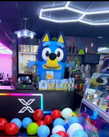 Person in a Bluey costume at a colorful entertainment counter.