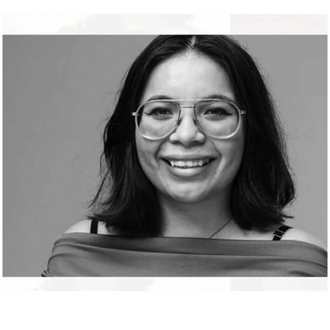 Black and white portrait of a smiling woman wearing glasses.