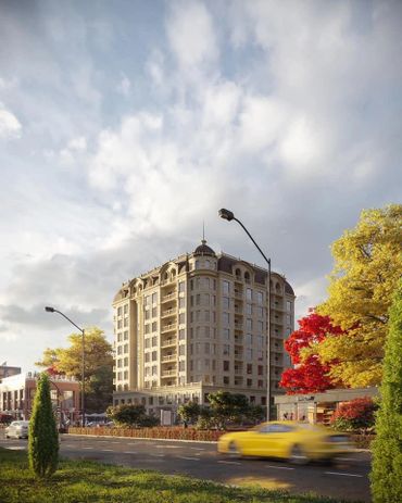 Elegant tall building surrounded by autumn trees and a passing yellow car.