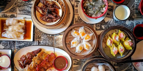 A vibrant spread of dim sum dishes on a patterned table.