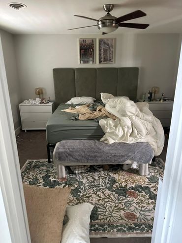 Untidy bedroom with unmade bed and cluttered nightstands.