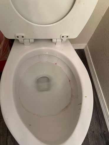 White toilet bowl with visible stains inside.