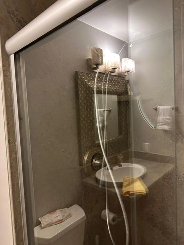 Small bathroom with a glass shower door and a sink with a mirror.