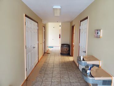 A clean hallway with tiled floor and multiple doors on each side.