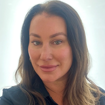 Close-up photo of a woman with long brown hair and blue eyes.