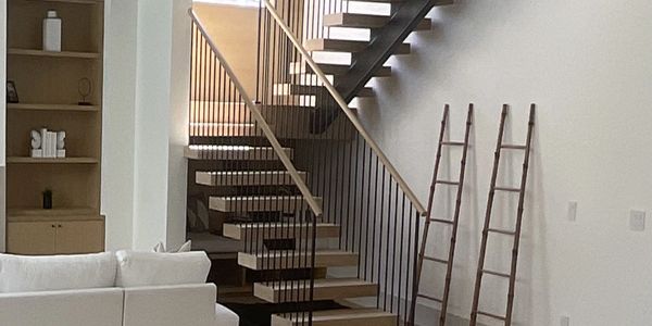Modern interior with floating stairs and wooden ladders.