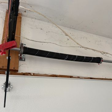Garage door torsion spring mounted above the door.