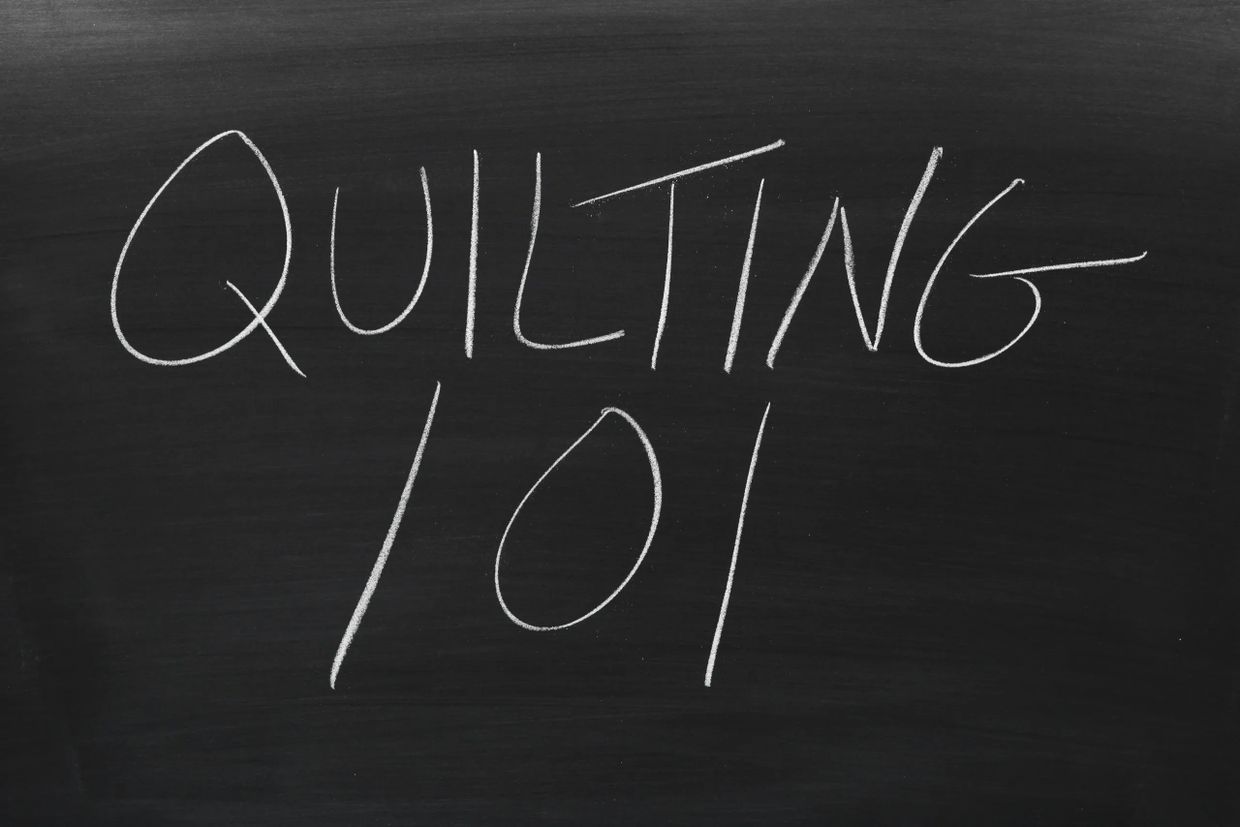 "Quilting 101" written in white chalk on a blackboard.