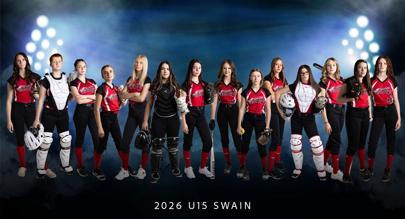Youth girls' softball team posing in uniform with equipment under stadium lights.