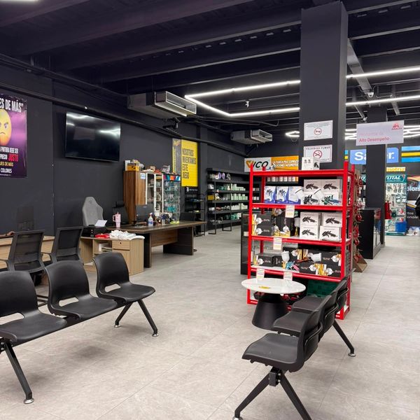 Modern waiting area with black chairs and a retail display in a spacious room.