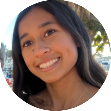 Young woman smiling outdoors near a marina.