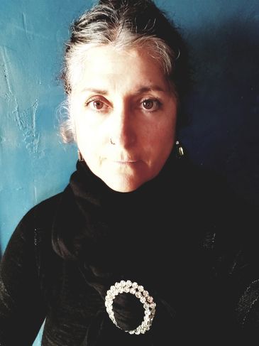 photo of a dark eyed woman in black with a rhinestone pin JA St Thomas