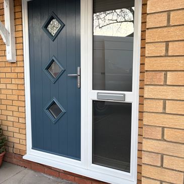 Blue front door with three diamond-shaped windows next to a white-framed glass panel.