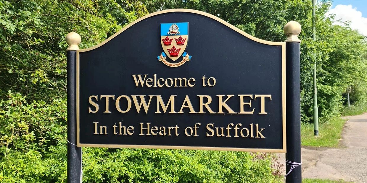 Welcome sign for Stowmarket, Suffolk, surrounded by greenery.