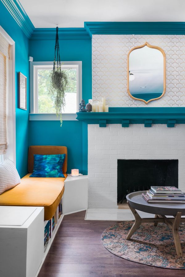 Cozy teal living room corner with mustard bench seat and fireplace.