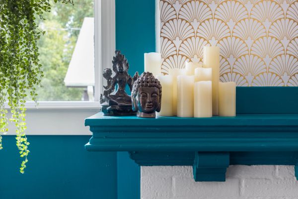 Decorative shelf with candles and Buddha statues.