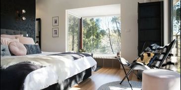 Sunlit and spacious master bedroom, with luxurious double spa bath with private bush land views. 