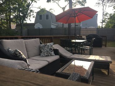 View of back deck showing outdoor seating area, eating area and grill
