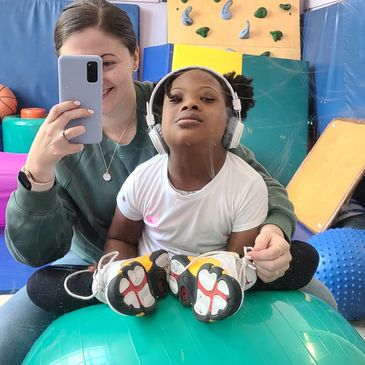 Child and adult posing for selfie in a playroom.