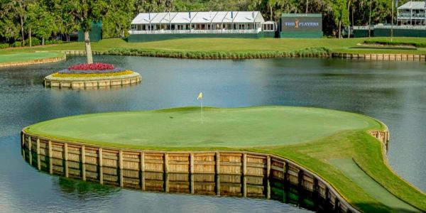 Golf green surrounded by water on a course.