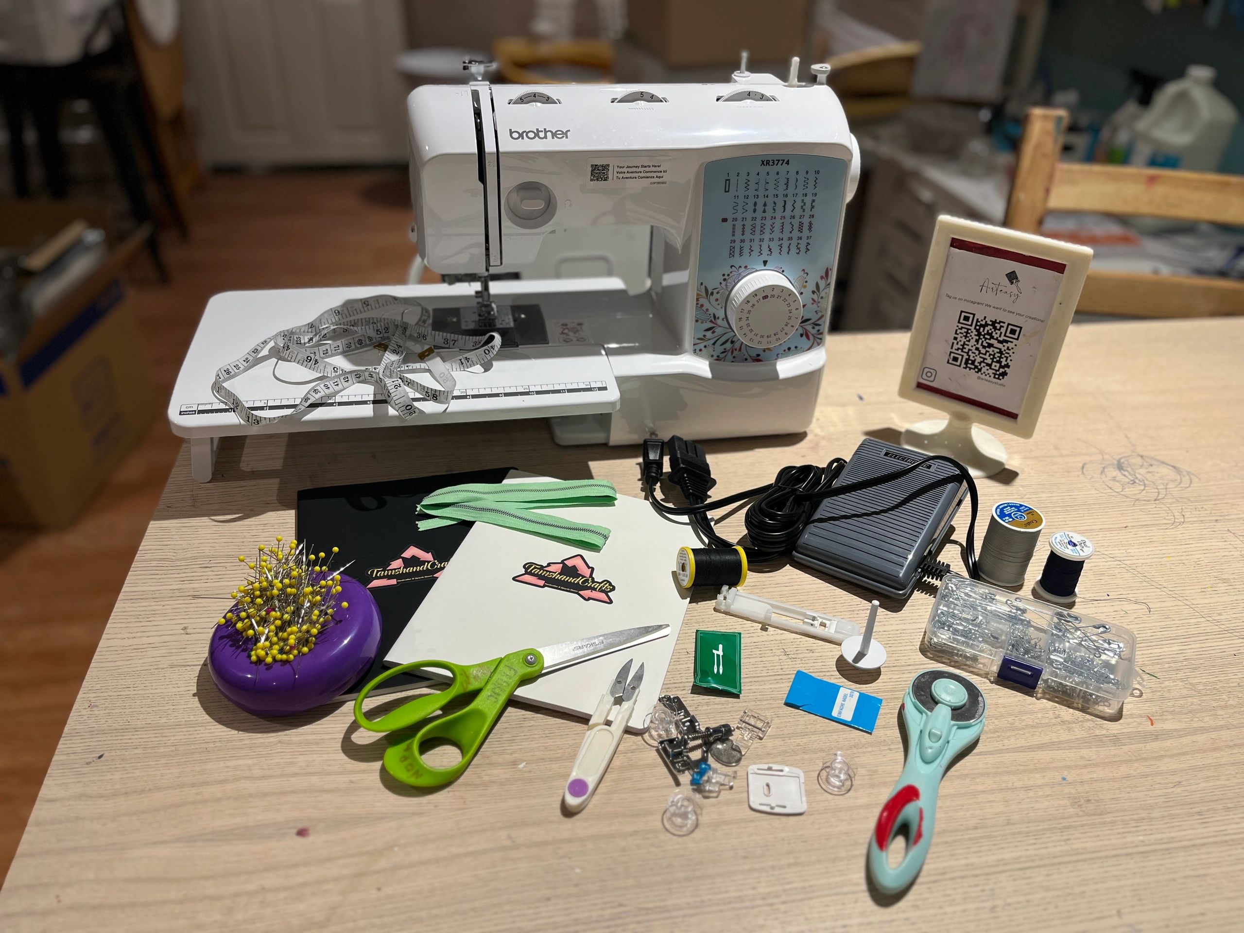 A sewing machine with various sewing tools and accessories on a wooden table.