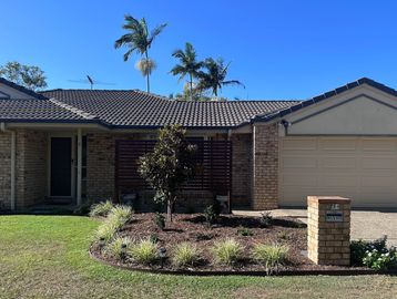 Single-story brick house with a tiled roof and garage.