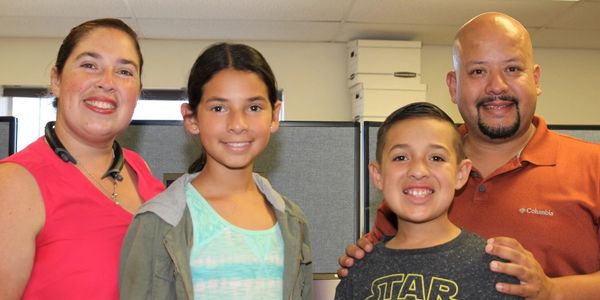 Family of four picking up a laptop for son.