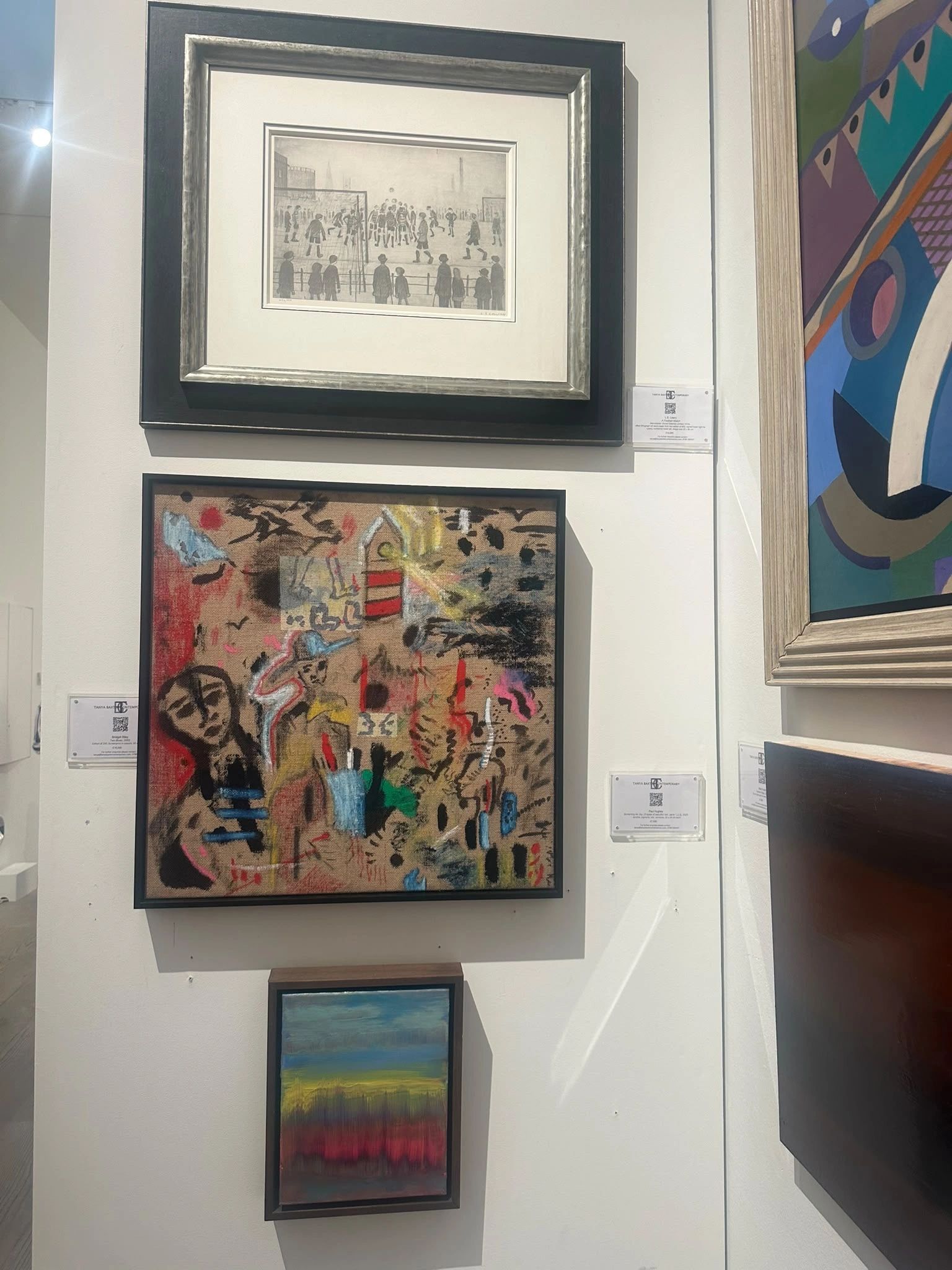 Gallery wall with diverse artwork styles.