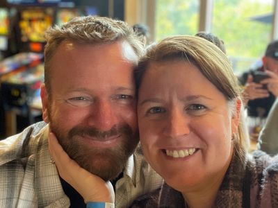 Smiling couple taking a close-up selfie indoors.