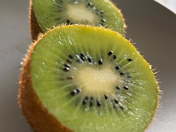 Close-up of a sliced kiwi showing vibrant green flesh and seeds.