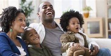 A happy family of four enjoying time together on the couch.