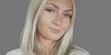 Portrait of a young woman with blonde hair and a subtle smile.