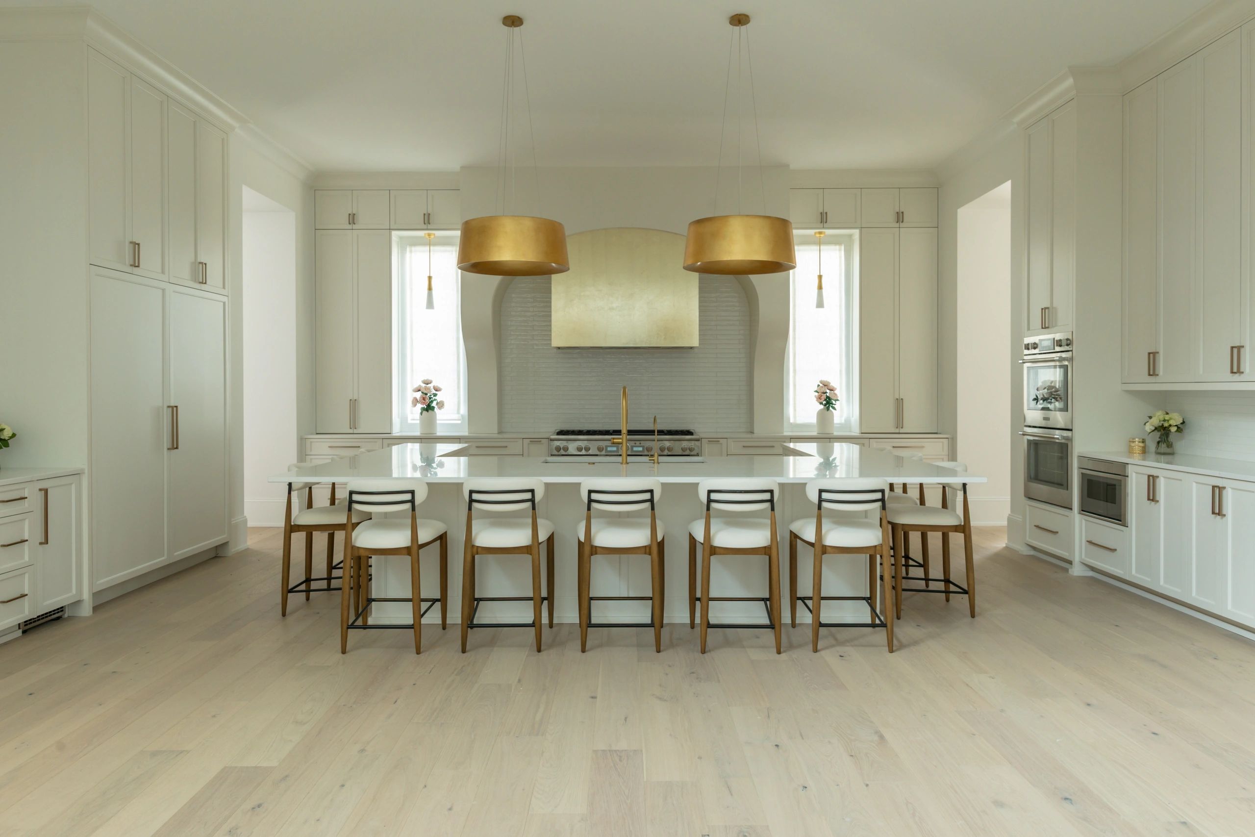 Spacious modern kitchen with white cabinetry and gold accents.