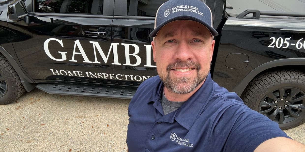 Man in branded uniform taking a selfie in front of a home inspection vehicle.