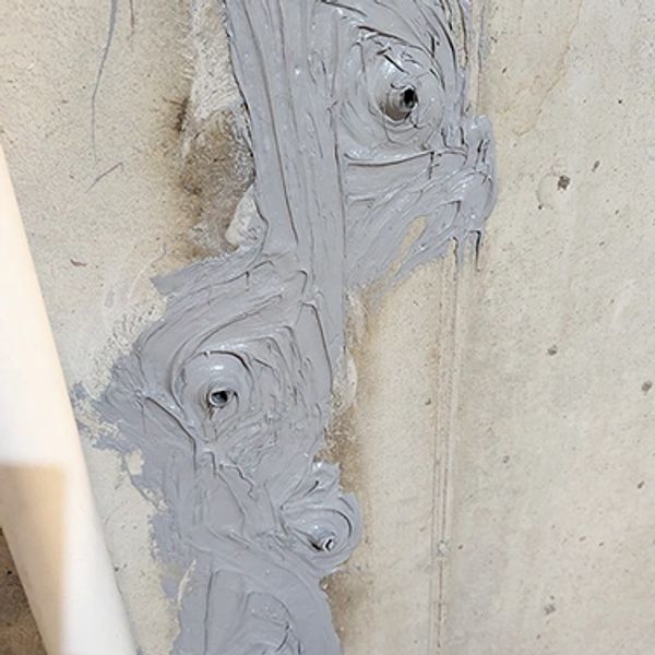 Epoxy-injected foundation wall crack with patched injection ports.