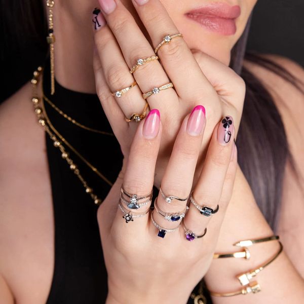 A close-up photo of a model's hands with various rings
