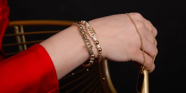 A photo of a woman's hand with bracelets on