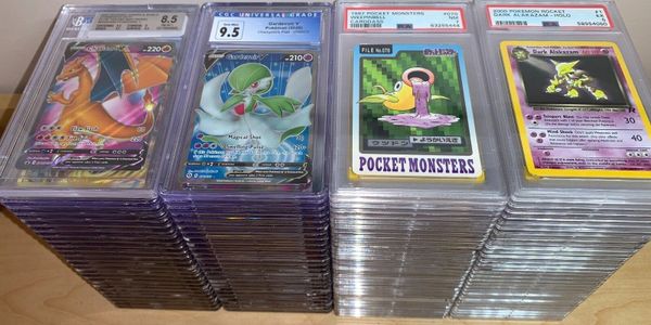 Stacks of graded Pokémon cards including Charizard, Gardevoir, and rare vintage cards.
