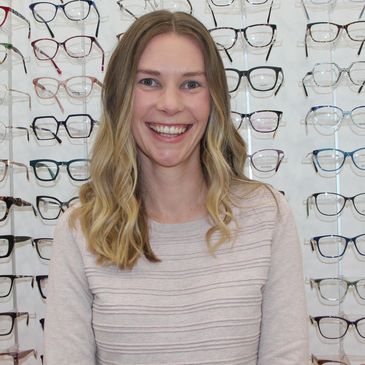 A scenic view of mountains under a clear blue sky with lush green trees in the foreground.